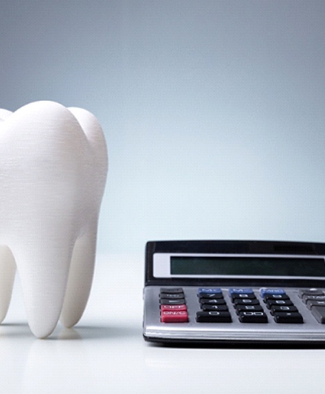 Model of tooth next to calculator