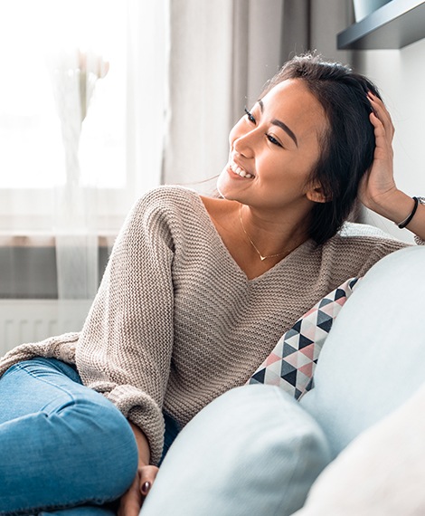 Woman smiling and sitting on couch