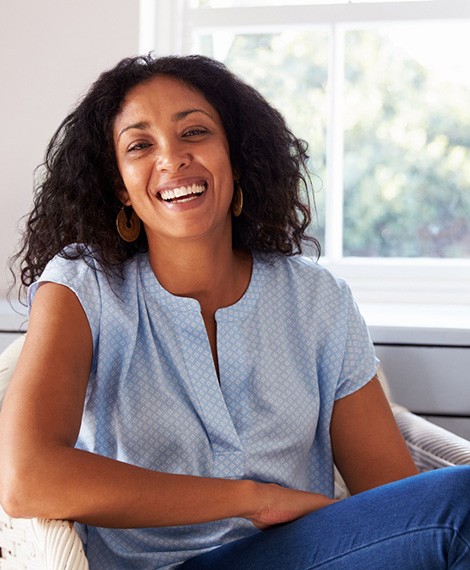 Woman in blue shirt smiling at home