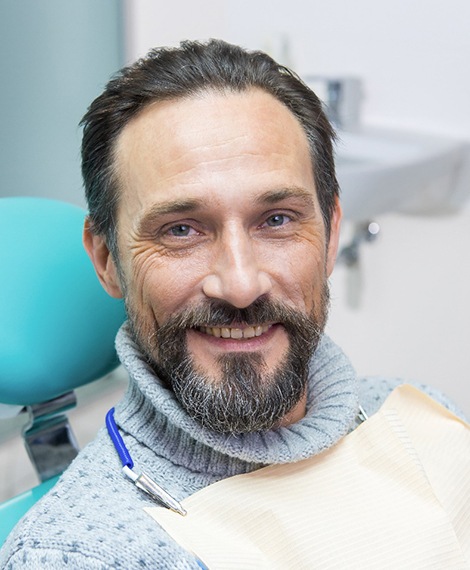 Bearded male patient sitting in chair and smiling