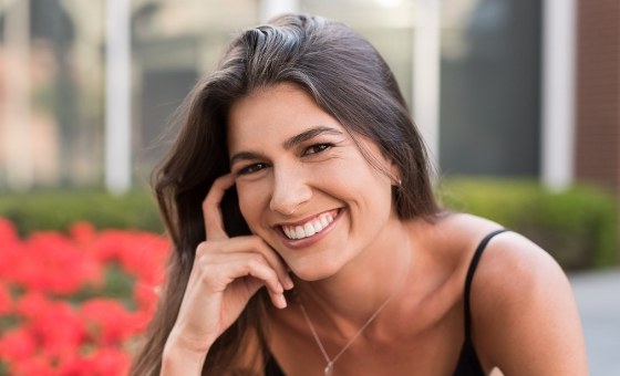 Woman smiling outdoors in black tanktop