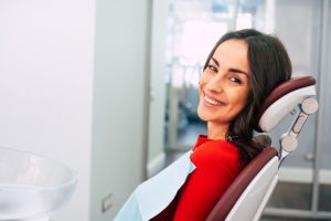 a woman sitting and smiling in the dentist’s chair