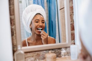 Woman flossing her teeth in bathroom.