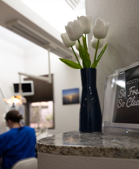 Vase with white tulips on dental office reception desk