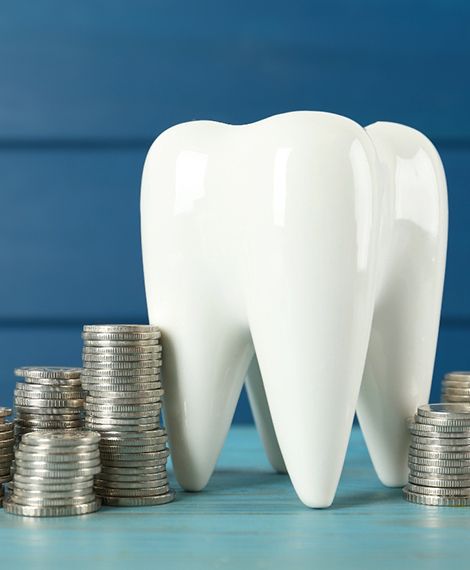 A model tooth and many silver coins set against a blue background