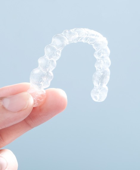 Closeup of clear aligner against blue background