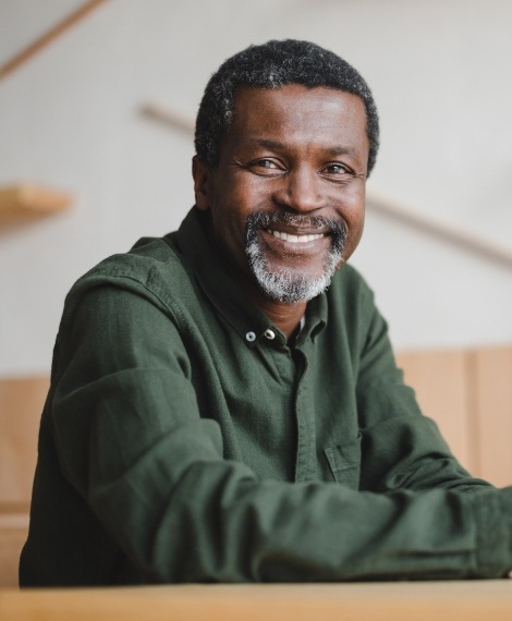 Man sharing flawless smile after dental implant tooth replacement