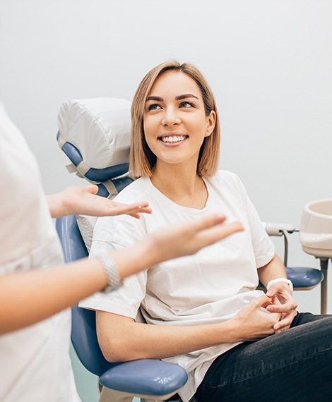 Woman in dental chair smiling at dentist