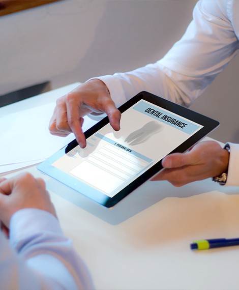 Two people looking at dental insurance forms on tablet