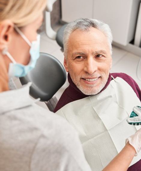 a patient smiling while undergoing the denture process