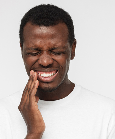 Man holding his cheek in pain