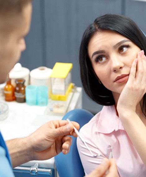 Young woman with toothache talking to her emergency dentist in Henderson