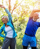 couple wearing exercise clothes stretching in a park