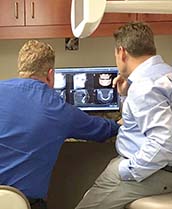Dentist looking at digital images of teeth