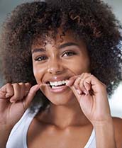 woman smiling while flossing