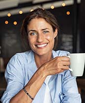 Smiling woman holding a white coffee mug