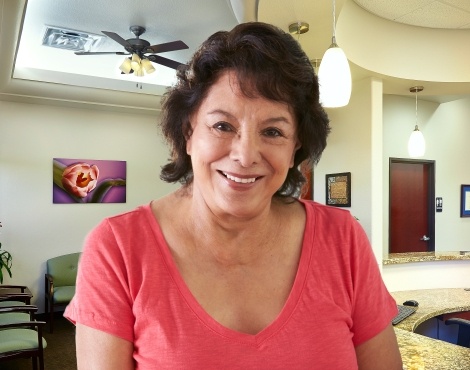 Smiling woman in peach colored blouse