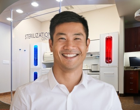 Man in white collared shirt grinning in dental office