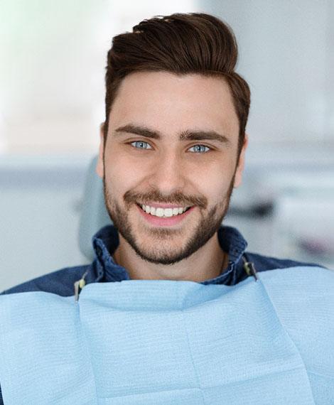 Man with short beard smiling in dental chair