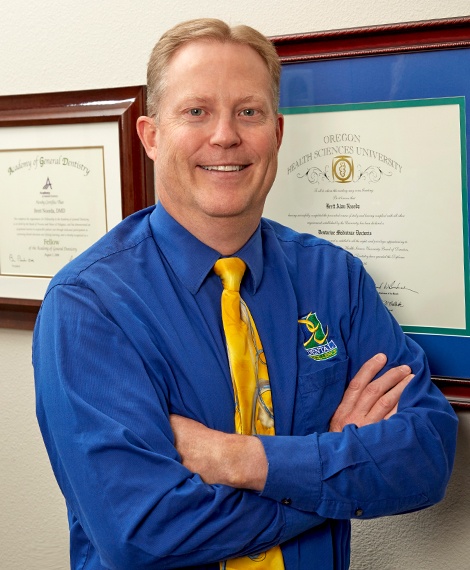 Doctor Noorda in front of diplomas and certificates