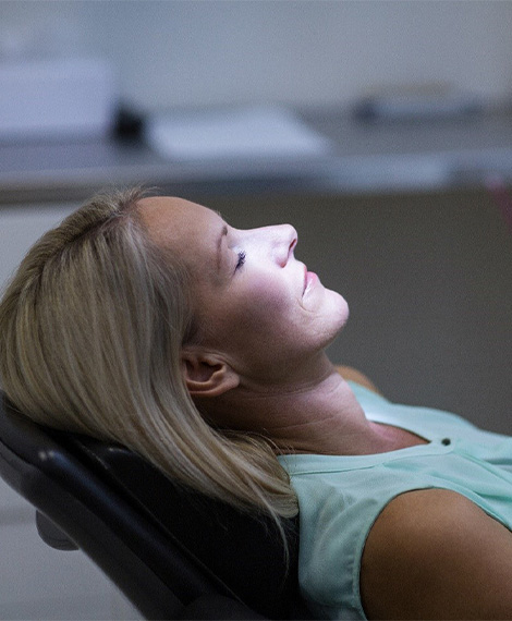 Young patient in dental chair with dental sedation mask in place