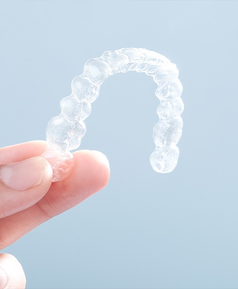 Person holding a sure smile aligner tray