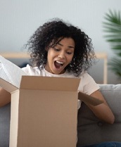 Woman excitedly opening a cardboard box