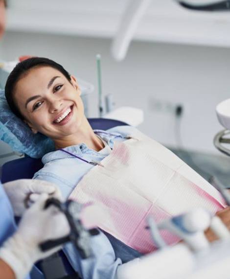 Happy dental patient reclining in treatment chair