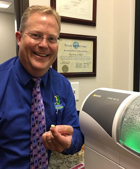 Doctor Noorda holding a dental crown crafted using the CEREC system