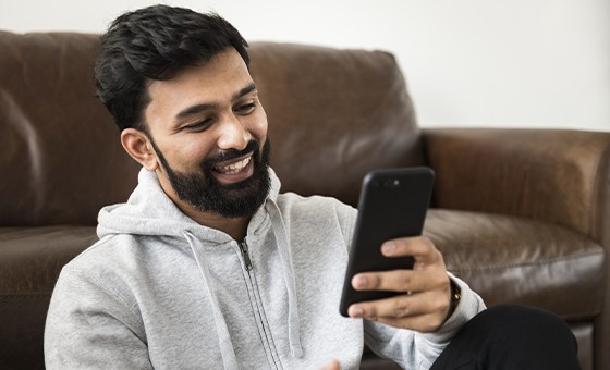 Young man in gray hoodie looking at his phone