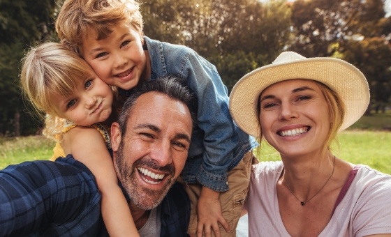 Mother father and two children smiling after dental services in Henderson