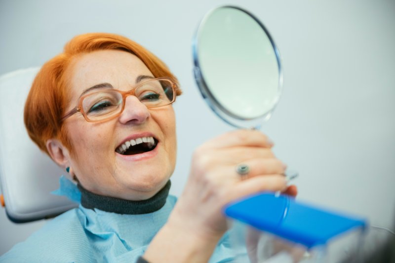 A woman enjoying her newly replaced dentures