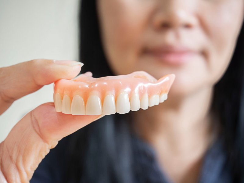 A hand holding a removable denture