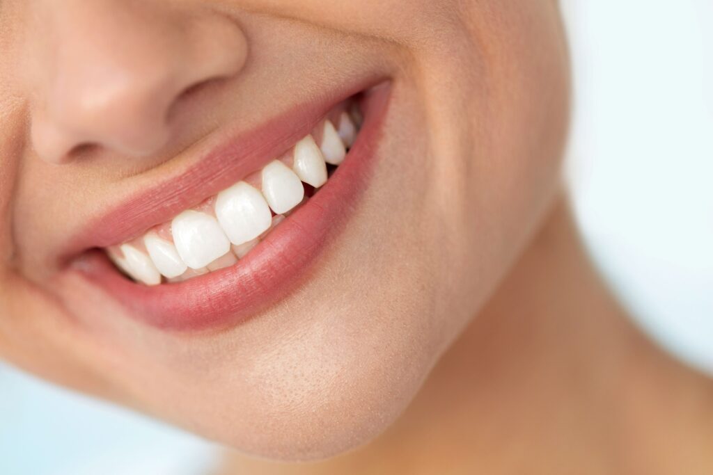 Nose-to-neck view of woman smiling. 
