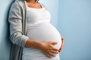 Pregnant woman holding belly.